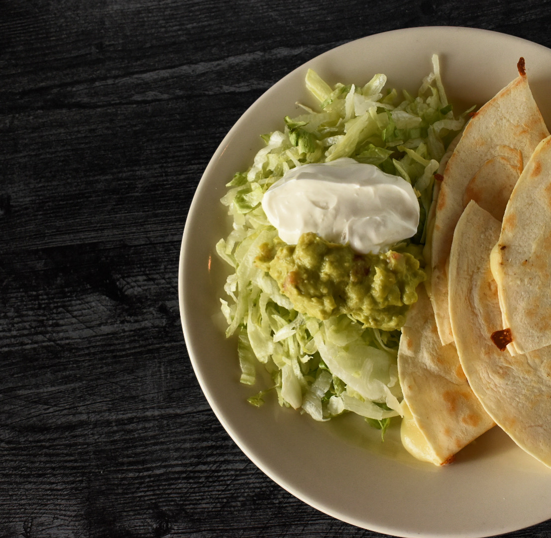 Tortillas served with lettuce, guacamole, and sour cream